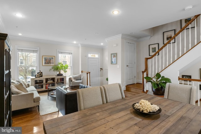 dining space with crown molding and light hardwood / wood-style flooring