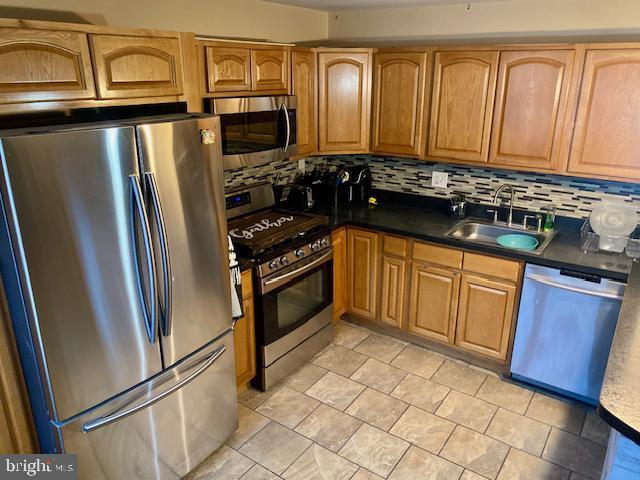 kitchen featuring sink, backsplash, and appliances with stainless steel finishes