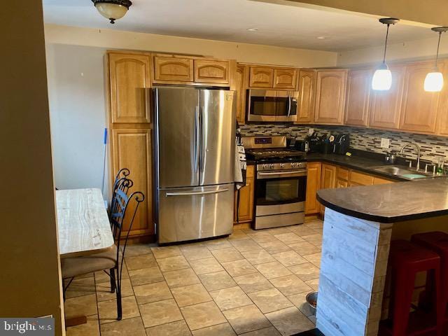 kitchen featuring stainless steel appliances, decorative light fixtures, sink, and decorative backsplash