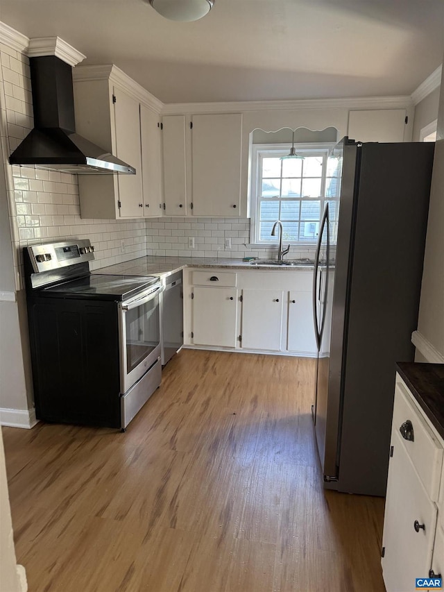 kitchen with wall chimney range hood, backsplash, stainless steel appliances, and white cabinets