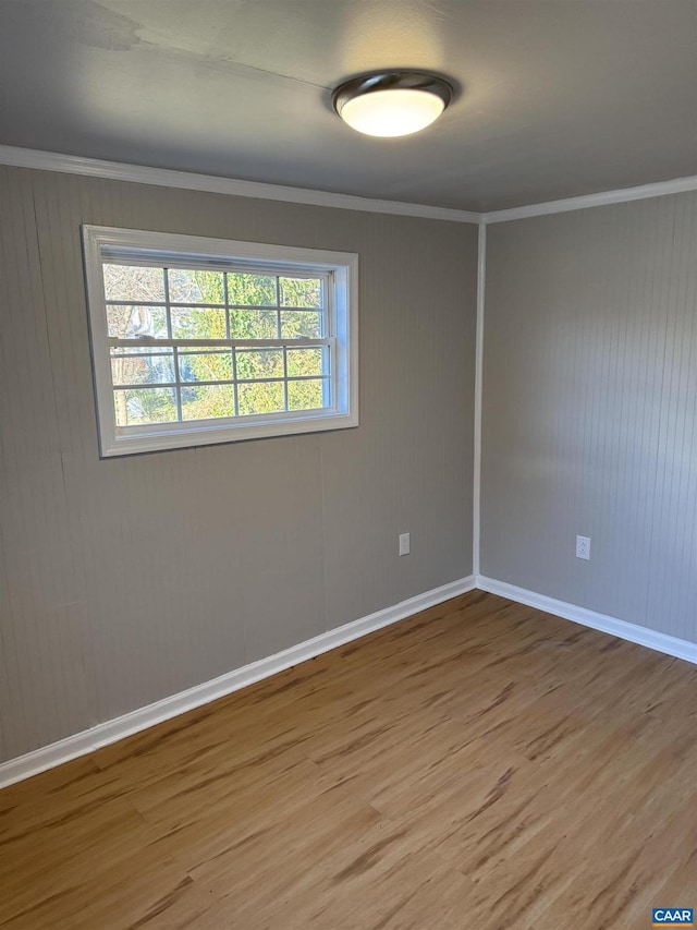 empty room with ornamental molding and wood-type flooring