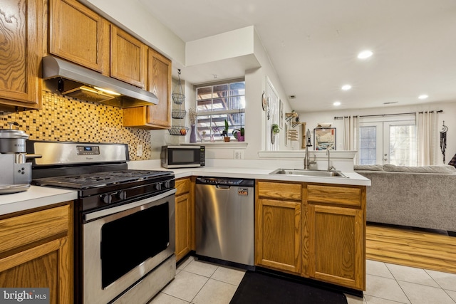 kitchen featuring sink, light tile patterned floors, appliances with stainless steel finishes, tasteful backsplash, and ventilation hood