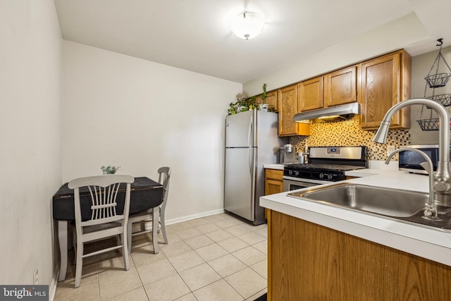 kitchen with sink, decorative backsplash, stainless steel appliances, and light tile patterned flooring