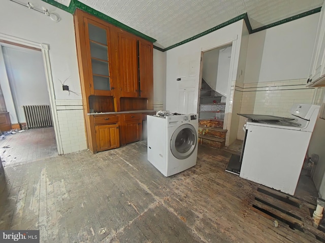 clothes washing area featuring washer / clothes dryer and radiator heating unit