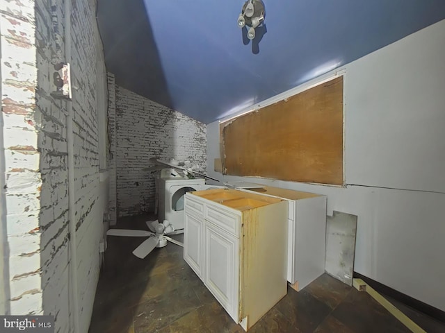 laundry area with washer / clothes dryer and brick wall