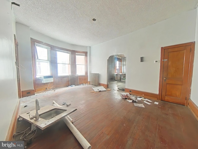 interior space featuring sink, dark hardwood / wood-style floors, radiator heating unit, and a textured ceiling