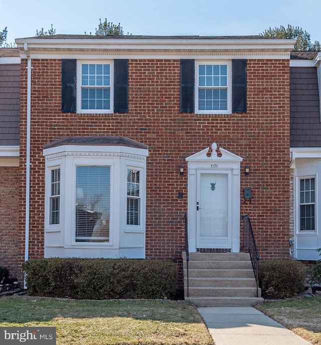 townhome / multi-family property featuring entry steps and brick siding