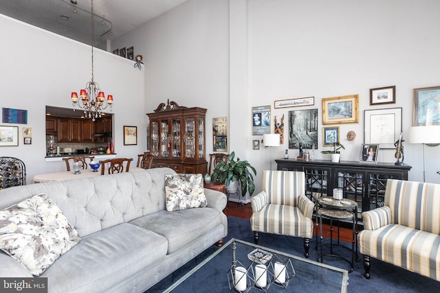 living room featuring an inviting chandelier and a high ceiling