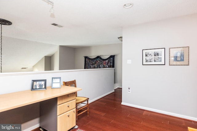 office space featuring dark hardwood / wood-style floors, built in desk, and vaulted ceiling