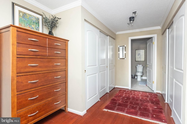 hallway with crown molding, dark hardwood / wood-style floors, and a textured ceiling