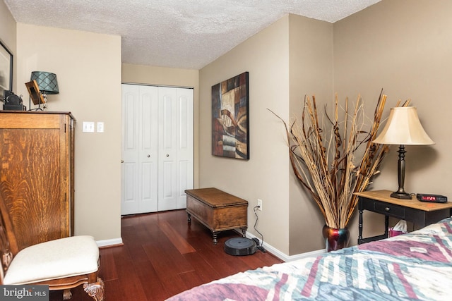 bedroom with dark wood-type flooring, a closet, and a textured ceiling