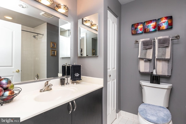 bathroom with a tile shower, sink, tile patterned floors, and toilet