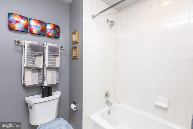 bathroom with toilet and tiled shower / bath