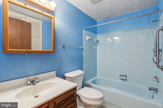 full bathroom with vanity, tiled shower / bath, toilet, and a textured ceiling