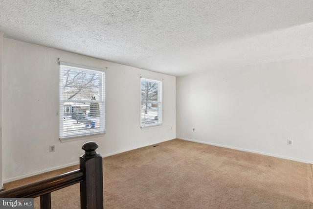 unfurnished room featuring light carpet and a textured ceiling