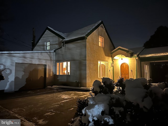 property exterior at night featuring a garage