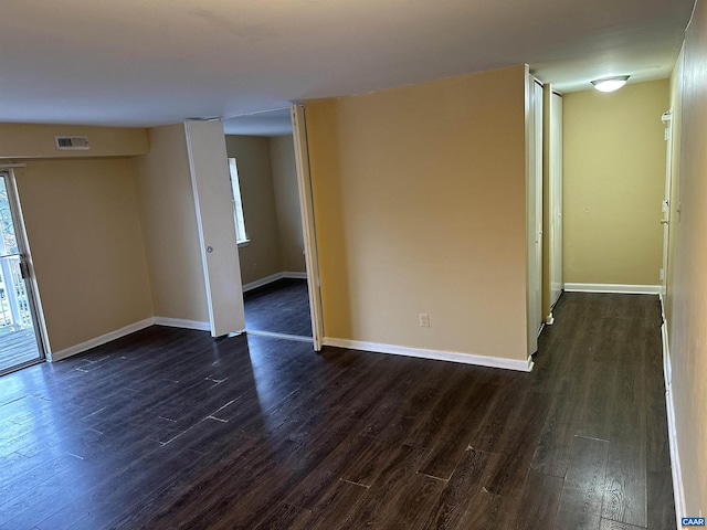 unfurnished room with dark hardwood / wood-style flooring