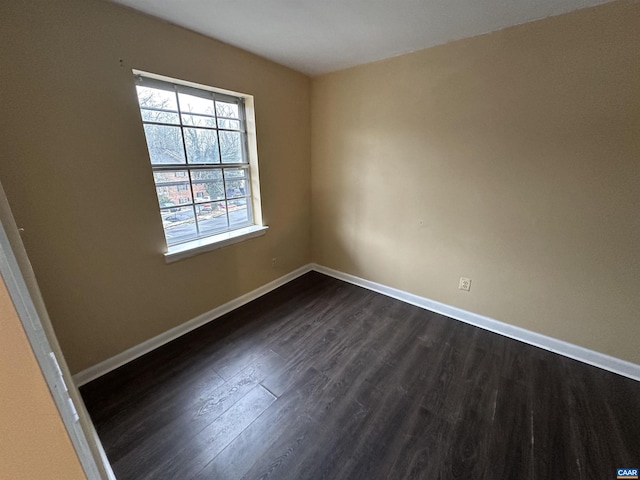 unfurnished room with dark wood-type flooring