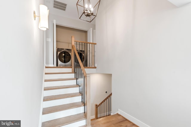 stairs featuring hardwood / wood-style flooring and washer / dryer