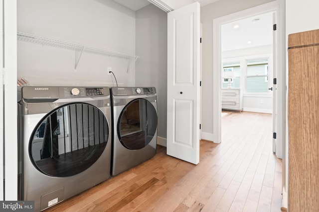 washroom with washer and clothes dryer and light wood-type flooring