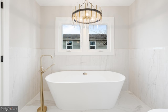 bathroom featuring a washtub and a notable chandelier