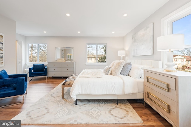 bedroom with multiple windows and hardwood / wood-style floors