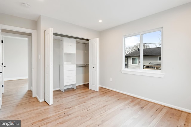 unfurnished bedroom featuring light wood-type flooring and a closet