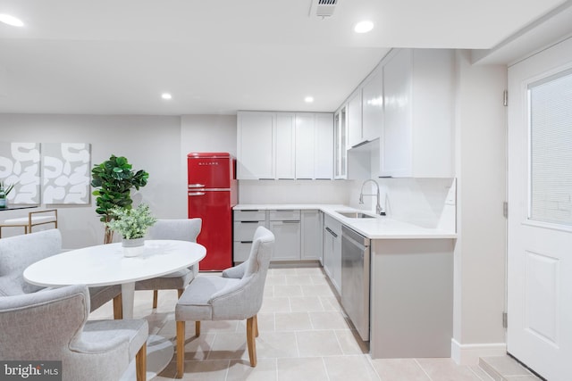 kitchen with sink, decorative backsplash, fridge, stainless steel dishwasher, and light tile patterned floors