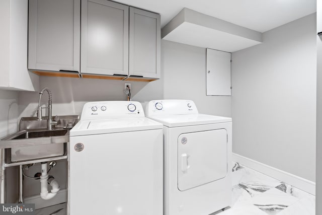 laundry area featuring cabinets, washing machine and dryer, and sink