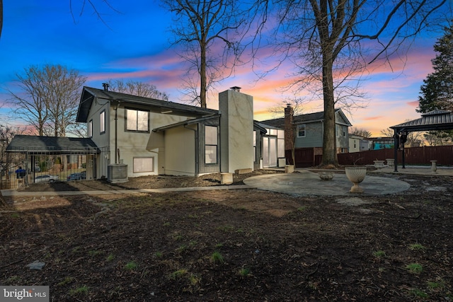 back house at dusk featuring a gazebo, a patio, and cooling unit