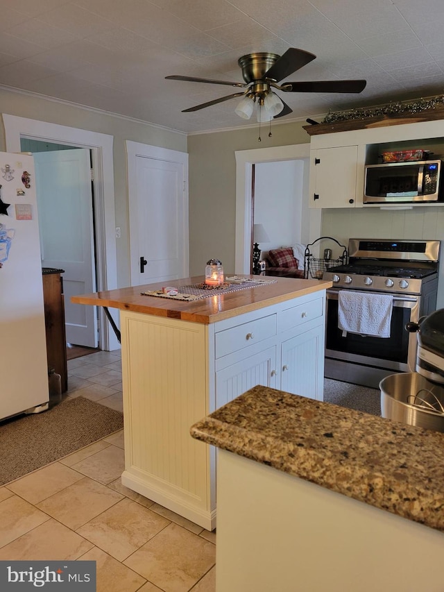 kitchen with stainless steel appliances, white cabinetry, a kitchen island, and crown molding