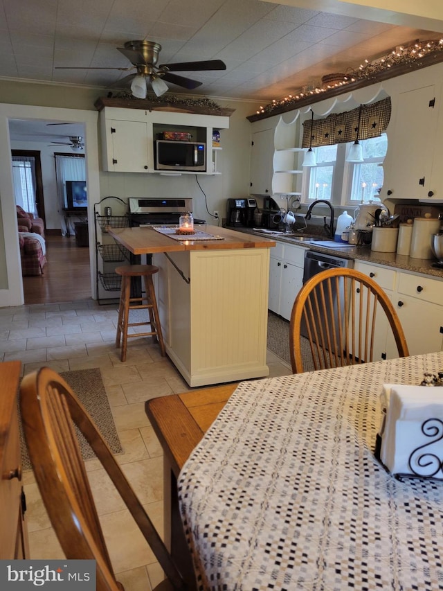 kitchen with white cabinetry, crown molding, dishwashing machine, and ceiling fan