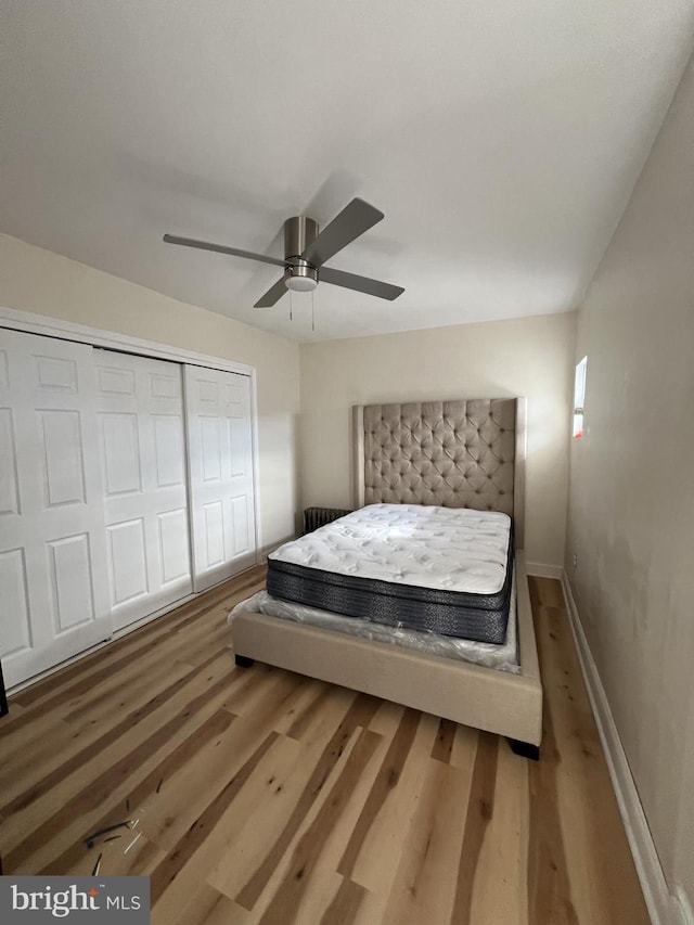 bedroom featuring hardwood / wood-style flooring, a closet, and ceiling fan