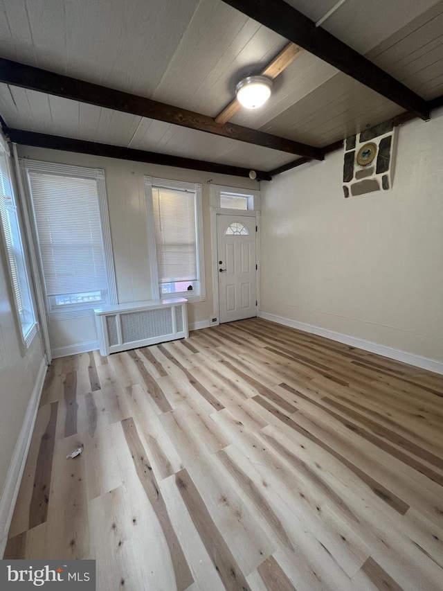 foyer entrance featuring beamed ceiling, radiator heating unit, and light hardwood / wood-style flooring