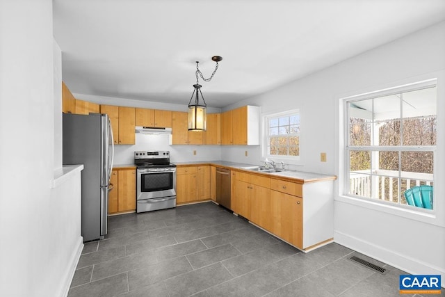 kitchen with pendant lighting, stainless steel appliances, sink, and a wealth of natural light