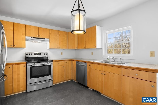 kitchen featuring stainless steel appliances, decorative light fixtures, and sink