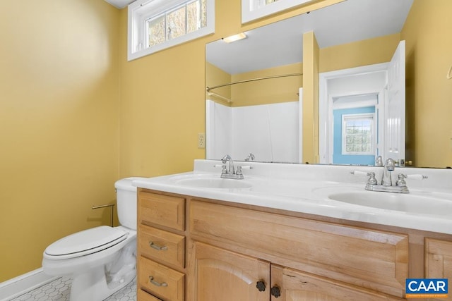 bathroom featuring tile patterned flooring, vanity, a shower, and toilet