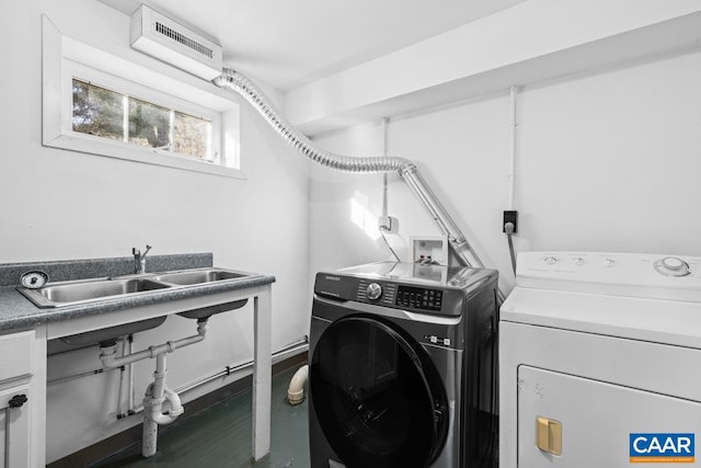 clothes washing area with sink, a wall unit AC, and washing machine and clothes dryer