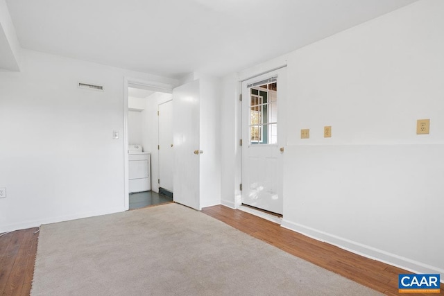 empty room with dark hardwood / wood-style flooring and washer / dryer