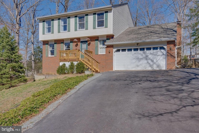 view of front facade featuring brick siding, driveway, a chimney, and an attached garage