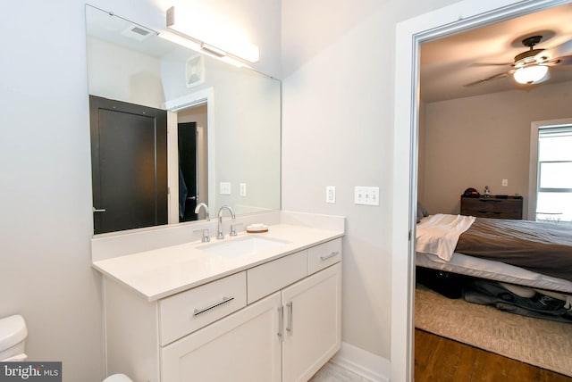 bathroom featuring vanity, hardwood / wood-style floors, ceiling fan, and toilet