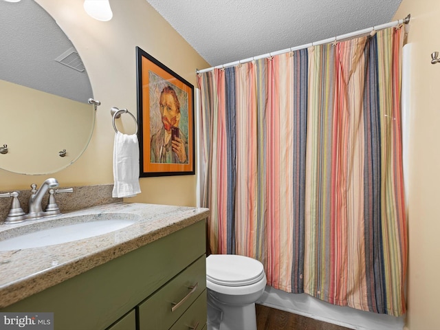 bathroom with toilet, a shower with curtain, wood-type flooring, a textured ceiling, and vanity