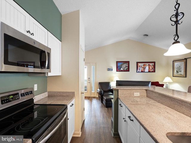 kitchen with lofted ceiling, white cabinetry, stainless steel appliances, light stone counters, and decorative light fixtures