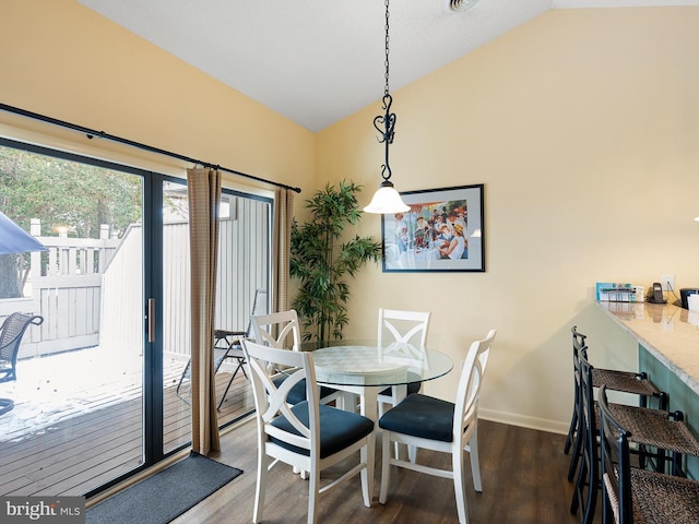 dining room featuring dark wood-type flooring and vaulted ceiling