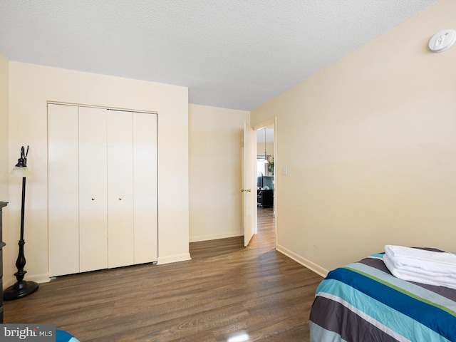 bedroom featuring dark hardwood / wood-style floors, a closet, and a textured ceiling