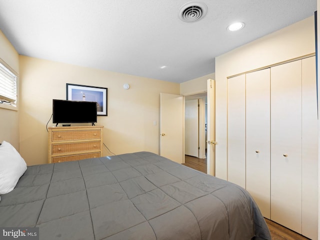 bedroom with wood-type flooring and a closet