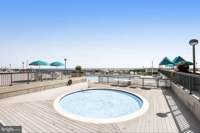 view of pool with a patio area and a water view