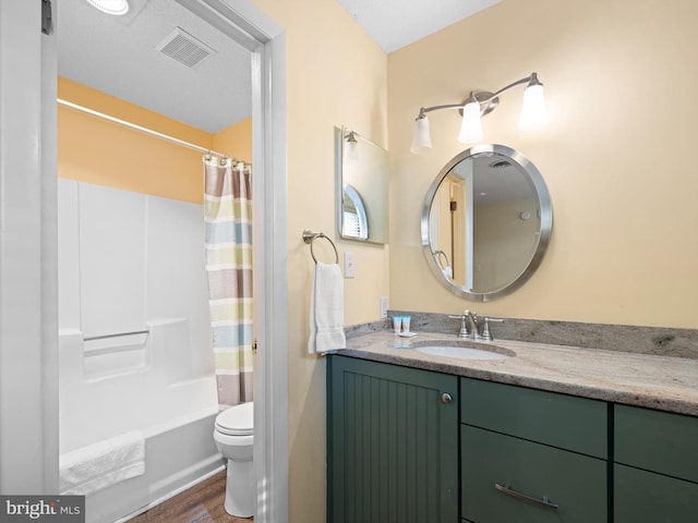 full bathroom with hardwood / wood-style flooring, vanity, toilet, a textured ceiling, and shower / bath combo with shower curtain