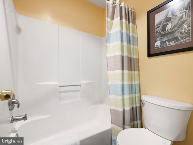 bathroom featuring shower / tub combo and toilet