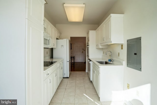 kitchen with light tile patterned flooring, sink, electric panel, white appliances, and white cabinets